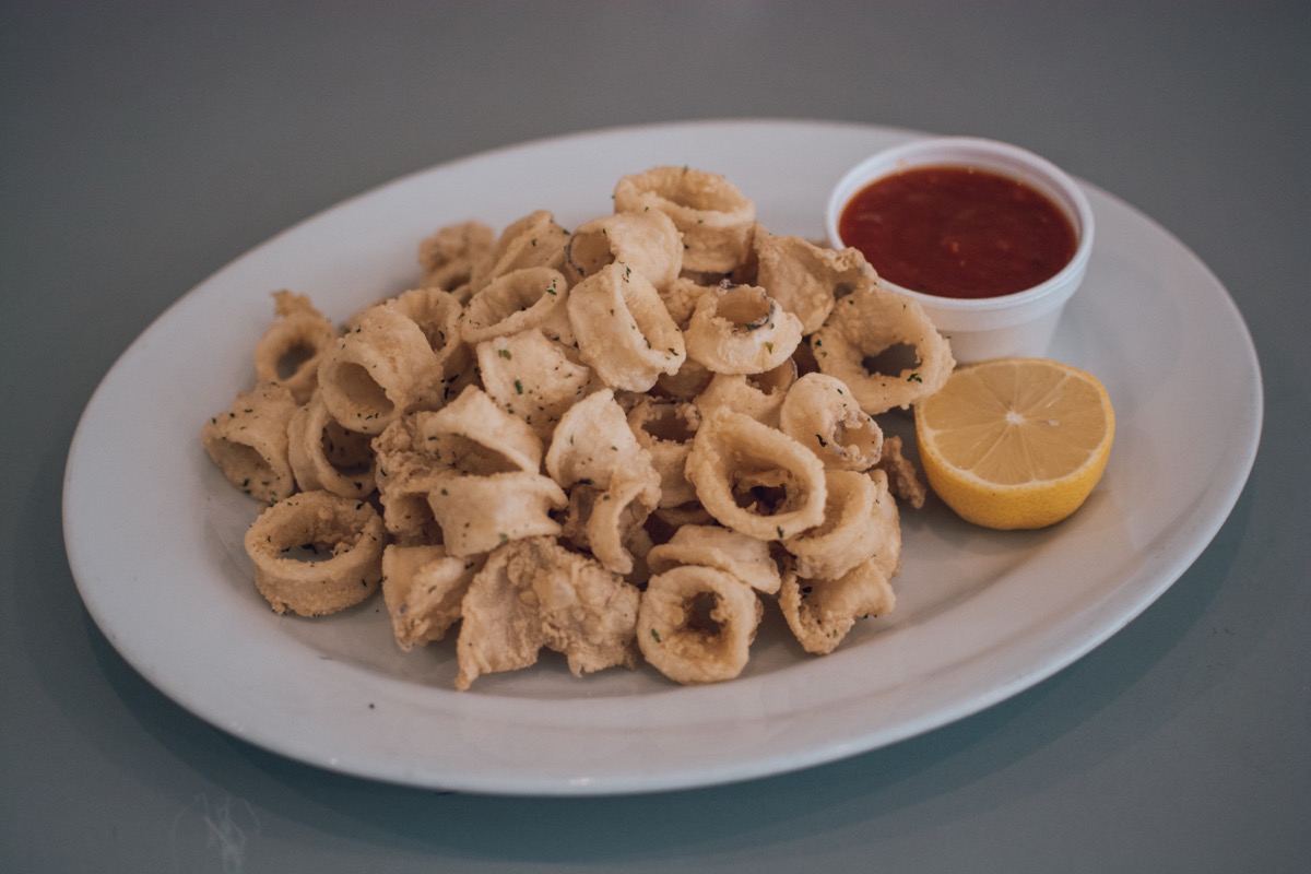 Plate of fried calamari with marinara sauce and lemon